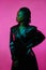 Glamorous fashion portrait of african american girl in leather coat. neon pink light