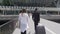 Glamorous female and bodyguard with her luggage walking at the airport, tourism