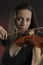 Glamorous girl with a long brown hair playing the violin