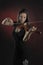 Glamorous girl with a long brown hair playing the violin