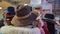 Glamorous lady putting on wide brimmed hat, posing, having fun at local market