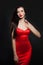 Glamorous model in red silky dress. Perfect brunette woman