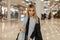 Glamorous pretty stylish young blond woman in a luxurious fashionable vintage vintage coat with a gray fashionable warm scarf