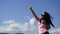 Glamour girl with long dark hair in the mountains makes selfi on the blue sky background