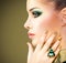 Glamour woman with beautiful golden nails and emerald ring