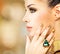 Glamour woman with beautiful golden nails and emerald ring