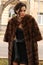 Glamour woman with dark hair wearing luxurious fur coat