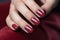 Glamour woman hand with classic red nail polish on her fingernails. Red nail manicure with gel polish at luxury beauty salon. Nail