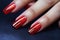 Glamour woman hand with classic red nail polish on her fingernails. Red nail manicure with gel polish at luxury beauty salon. Nail