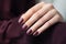 Glamour woman hand with deep berry and plum nail polish on fingernails. Nail manicure with gel polish at luxury beauty salon. Nail