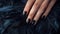 Glamour woman hand with luxury black color nail polish manicure on fingers, touching black feathers