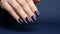 Glamour woman hand with navy blue nail polish on her fingernails. Navy nail manicure with gel polish at luxury beauty salon. Nail