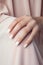 Glamour woman hand with shades nail polish on her fingernails. White nail manicure with gel polish at luxury beauty salon.