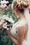 Glamourous blonde bride posing near magnolia flowers, newlywed bride portrait - beautiful woman in white dress posing near floral