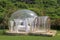 Glamping on Bali beach, in bubble house with transparent walls. White wooden double bed with mosquito net inside bubble. Honeymoon