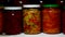 Glance slides along row of glass jars of pickled vegetables in pantry