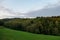 Glanz - A panoramic view on a lush wine region in South Styria, Austria. There is a dense forest in front and a vast pasture