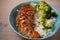 Glased chicken breast, rice and broccoli as garnish. Chicken in balsamic vinegar and brown sugar sauce.