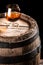 Glass of aged cognac and old wooden barrel