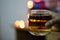 a glass of alcohol whisky held in hand with background blur bokeh lights