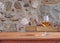 Glass of amber white wine on a rustic wooden table with an old stone wall behind. Background for copy space