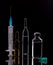 Glass ampoules and a plastic disposable syringe close up. Medical ampoules. Medical ampoules on a black background with reflection