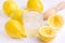 Glass ar of Cold Tasty Fresh Lemonade with Ripe Lemons Wooden Squeezer Close up