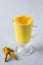 Glass of ayurvedic golden turmeric latte milk, curcuma powder on white