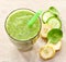 Glass of banana, spinach and cucumber smoothie with a straw