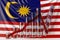 Glass bar chart with downward trend against flag of Malaysia. Financial crisis or economic meltdown related conceptual