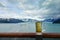 A glass of beer or beverage on the railing of a cruise ship while the ship is sailing away from the Hubbard Glacier