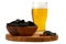 Glass of beer with black chips on wooden cutlery with red pepper