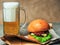 A glass of beer and a cheeseburger on a craft paper