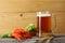 Glass beer with crawfish, hop cones and wheat ears with light wooden background. Beer brewery concept. Beer background