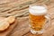 Glass of beer with ears of barley and bread on a wooden background