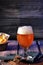 Glass of beer with foam and snacks in the background. Elaboration of craft beer. Brewing