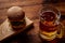 A glass of beer and a hamburger. Wooden dark background. Snack, food for beer