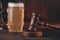 Glass of beer and judge gavel as a symbol of law on a wooden table close-up