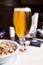 Glass of beer and peanut on the wooden background.