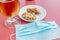 Glass of beer, plate of fried chicken wings and a face mask on a bar table