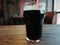 A glass of  beer standing on a wooden table in a cafe