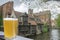 Glass of beer with view of historic houses and canal in city center in Bruges