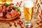 Glass of beer on wooden table background. Jamon and coated crunchy peanuts, great snack. Side view selective focus