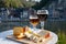 Glass of Belgian abbey beer and tasting of cheeses made with trappist beer and fine herbs with view on Maas river in Dinant