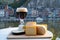 Glass of Belgian abbey beer and tasting of cheeses made with trappist beer and fine herbs with view on Maas river in Dinant,