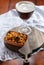 Glass of Belgian abbey red brown beer and glass bowl with party nuts