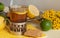 A glass of black tea in a glass holder, some biscuits, ripe lemons and limes on a linen surface against the light background