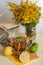 A glass of black tea in a glass holder, some biscuits, ripe lemons and limes on a linen surface against the light background