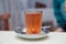 A glass of black tea . Patterned and spoon . Tea in a glass cup isolated on a blured background - Image. Nail and tea in the cup