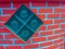Glass blocks on the red brick wall background. Square glass bloc